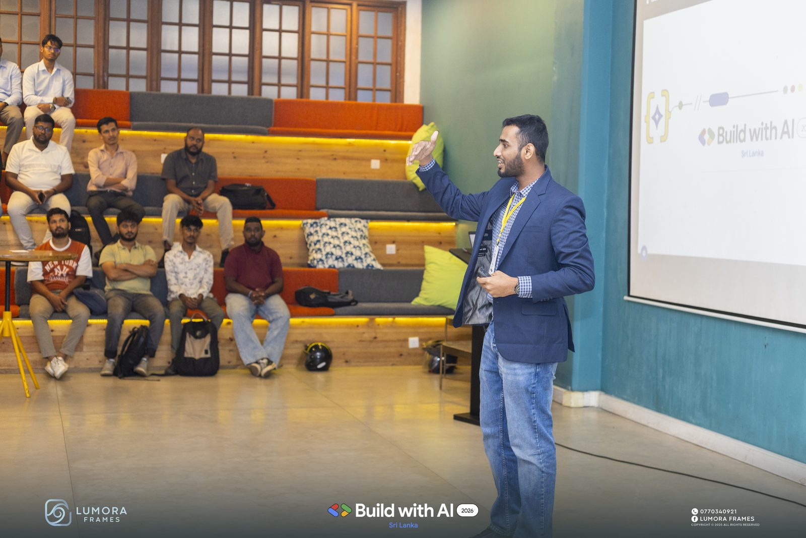 Ammar Ahamed speaking at Google Build with AI 2026 at Hatch Works, Colombo, to an audience seated on the tiered bleachers