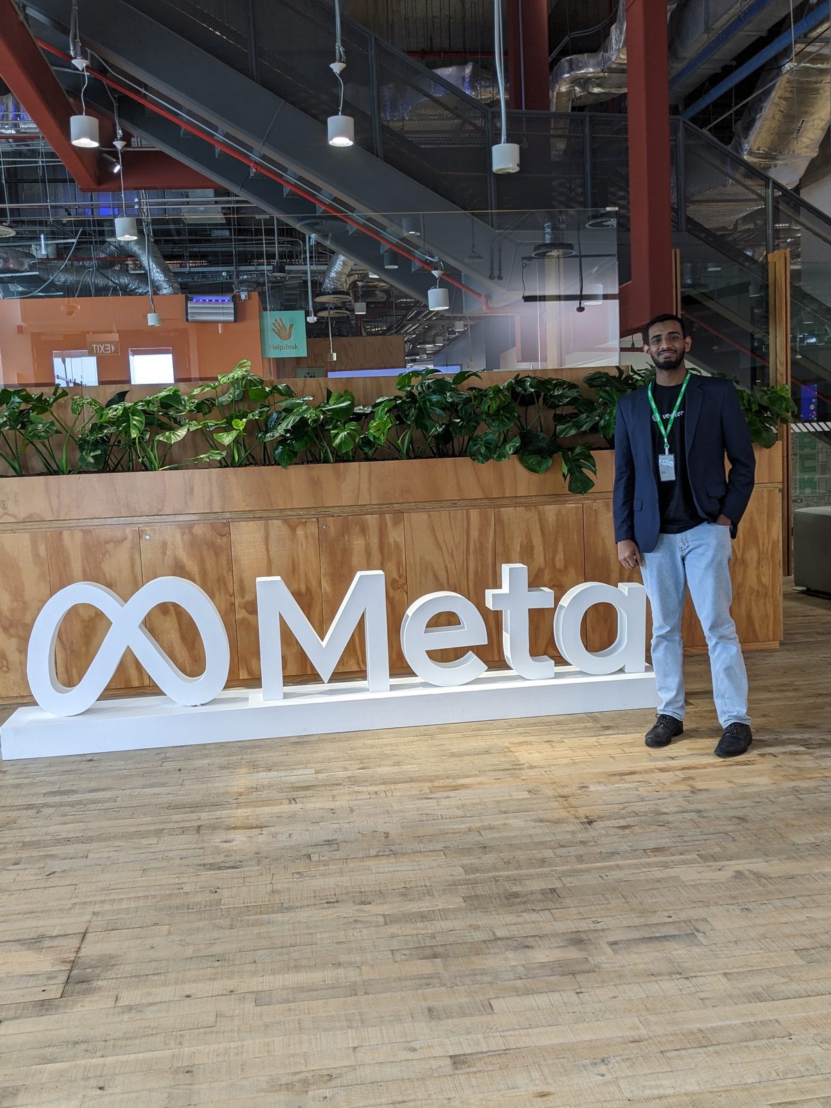 Ammar Ahamed beside the Meta sign inside Meta's Singapore office