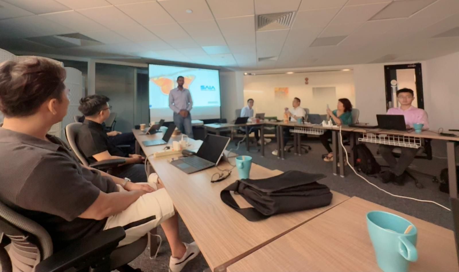 Working through problems around the table at the SAIA x Cocoon AI skills workshop in Singapore, facilitated by Ammar Ahamed