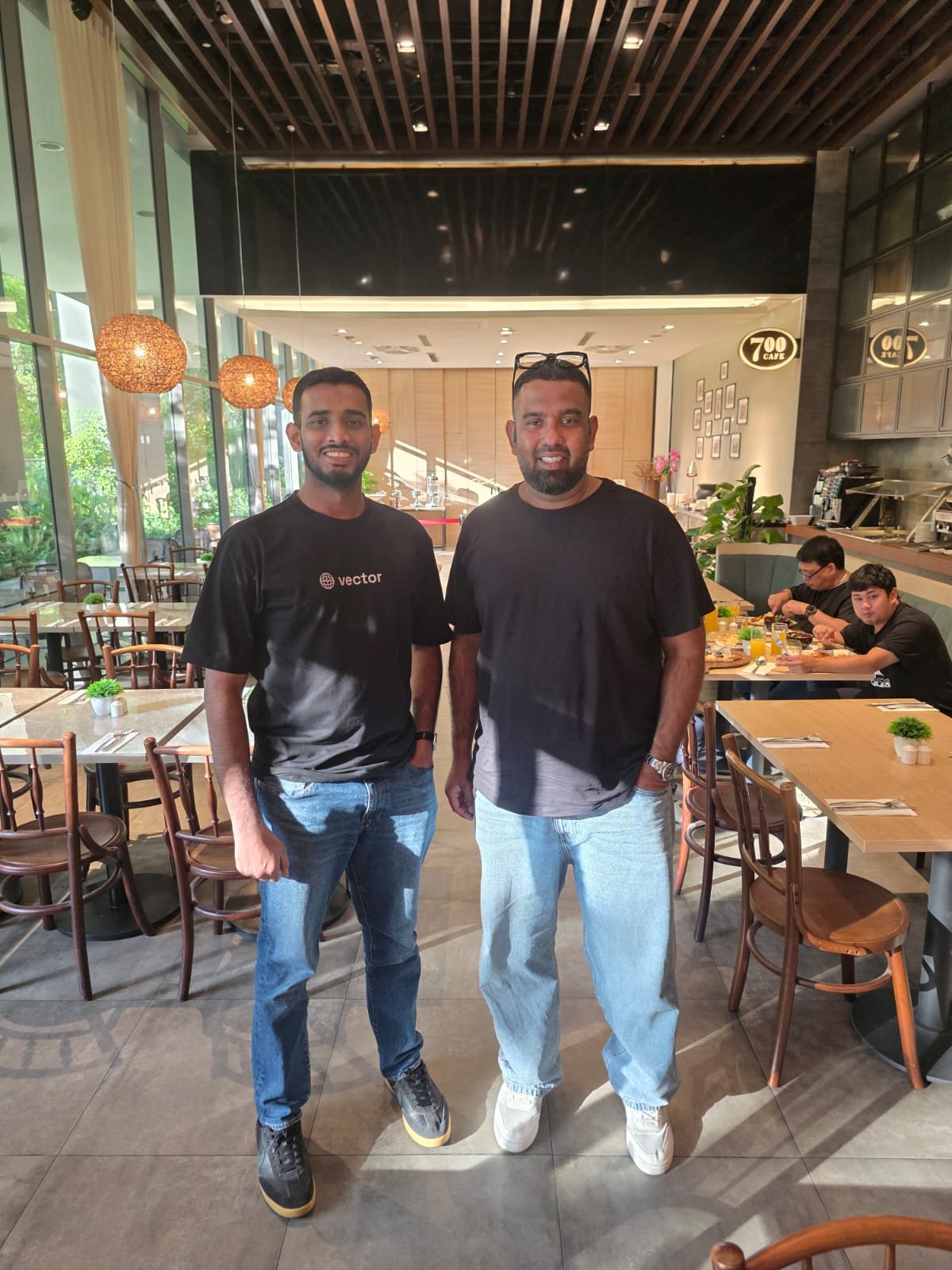 Ammar Ahamed in a Vector Agents shirt at a cafe in Singapore